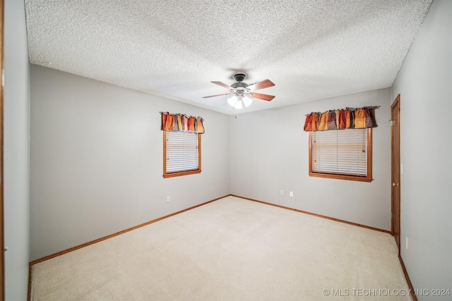 unfurnished room featuring ceiling fan, carpet floors, and a textured ceiling