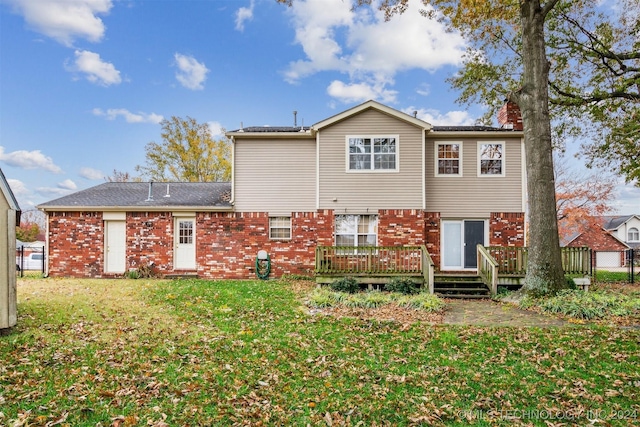 rear view of property featuring a deck and a lawn