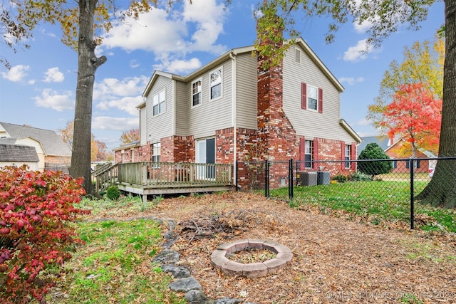 rear view of house with a fire pit and a deck