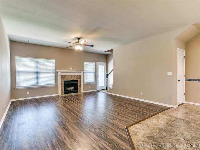 unfurnished living room with a fireplace, ceiling fan, and hardwood / wood-style floors