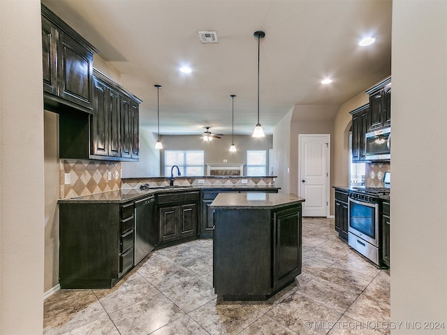 kitchen with backsplash, stainless steel appliances, ceiling fan, decorative light fixtures, and a kitchen island