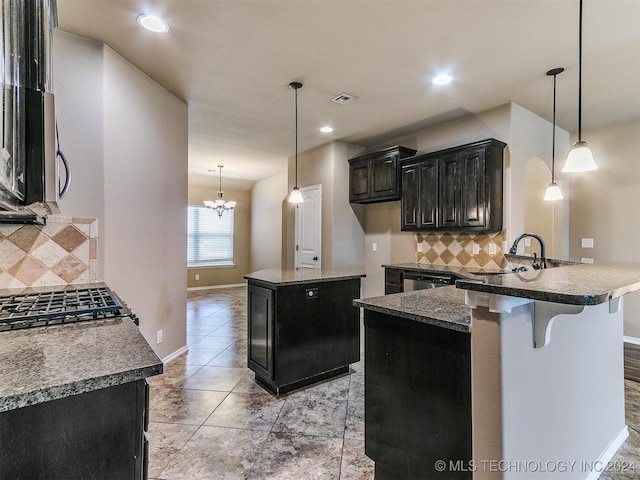 kitchen with a center island, backsplash, hanging light fixtures, and a chandelier