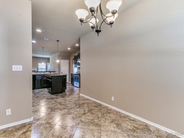 kitchen featuring a kitchen breakfast bar, a kitchen island with sink, decorative light fixtures, an inviting chandelier, and stainless steel range oven