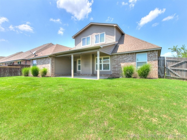 rear view of property featuring a yard and a patio