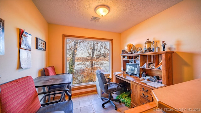 home office featuring light tile patterned floors and a textured ceiling