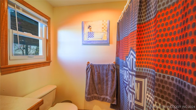 bathroom featuring a shower with shower curtain, vanity, and toilet