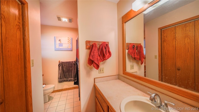 bathroom featuring tile patterned flooring, vanity, and toilet