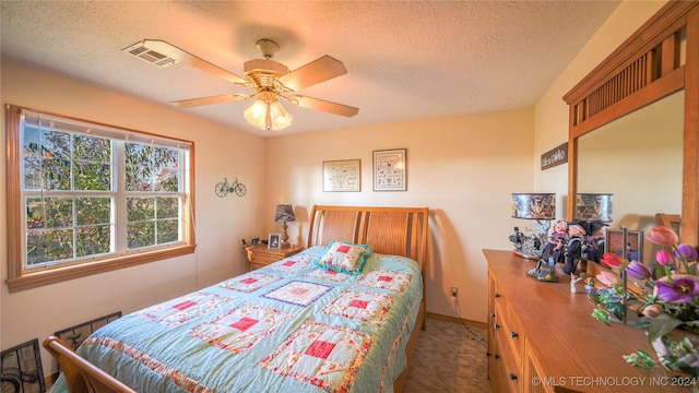 carpeted bedroom with ceiling fan and a textured ceiling