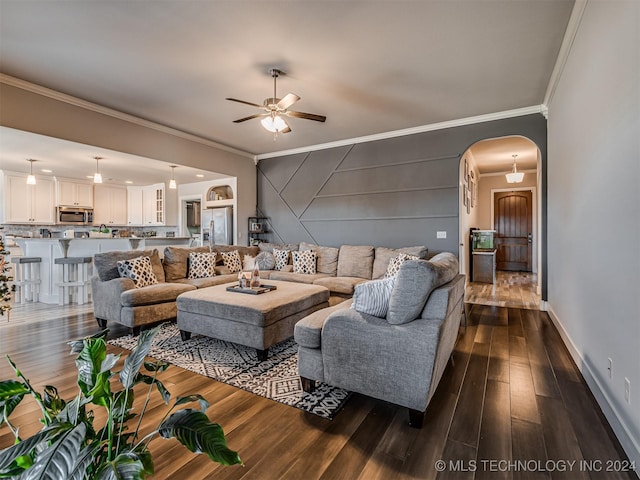 living room with crown molding, ceiling fan, and dark wood-type flooring