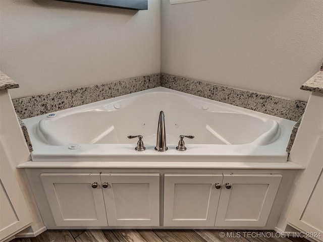 bathroom with wood-type flooring and a bathtub