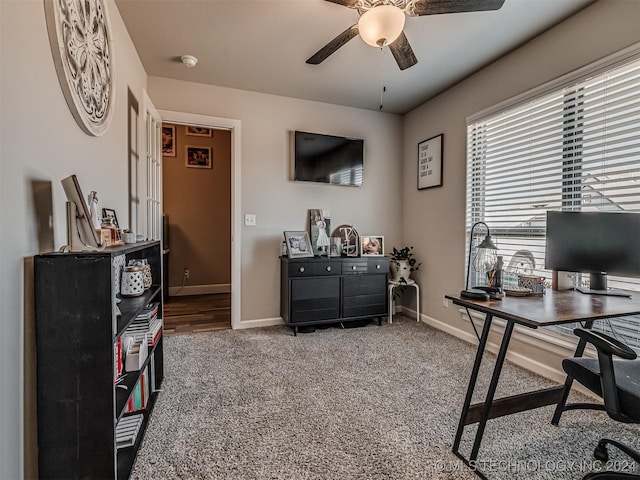 carpeted office space featuring ceiling fan