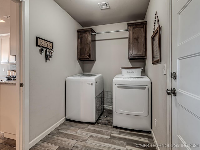 laundry room featuring washing machine and clothes dryer and cabinets