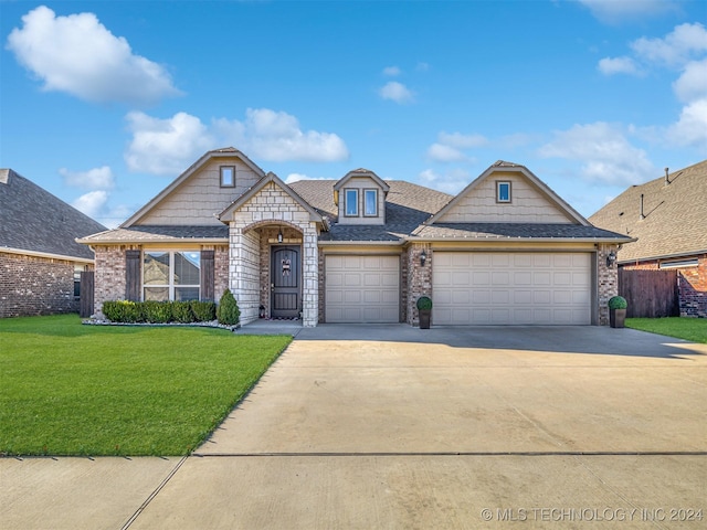 view of front of property featuring a front yard and a garage