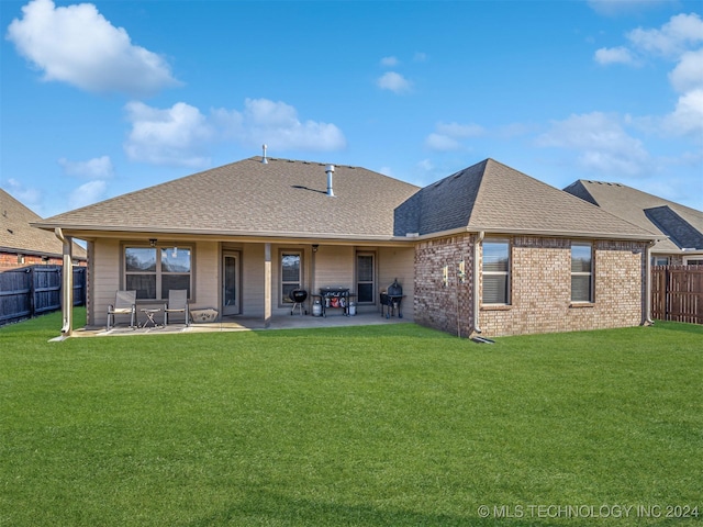 rear view of house featuring a yard and a patio area