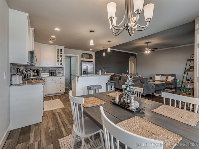 dining area with dark hardwood / wood-style floors and ceiling fan with notable chandelier