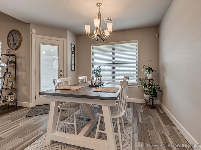 dining area featuring a chandelier and wood-type flooring