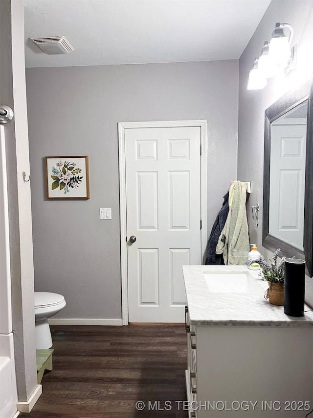 bathroom with a tub, wood-type flooring, toilet, and vanity