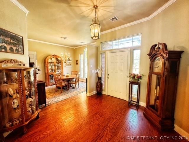 foyer featuring hardwood / wood-style floors, an inviting chandelier, and ornamental molding