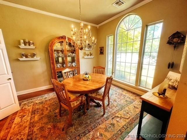 dining space with dark hardwood / wood-style floors, crown molding, and a notable chandelier