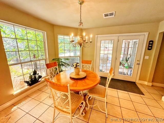 tiled dining area featuring an inviting chandelier