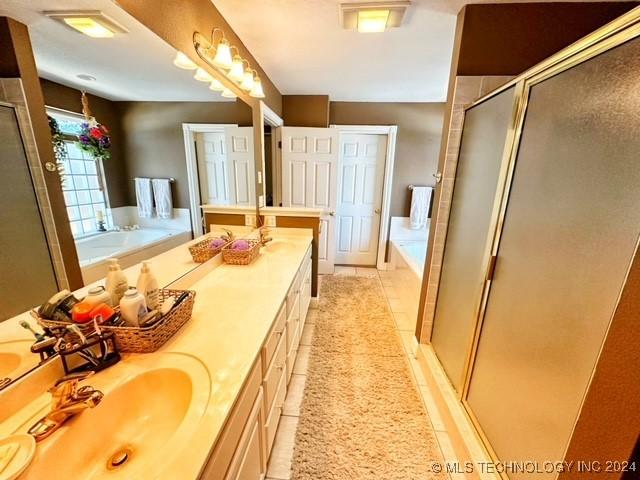 bathroom featuring tile patterned flooring, vanity, and independent shower and bath