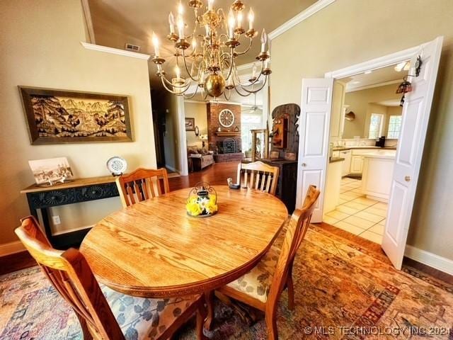 dining room with crown molding, light tile patterned flooring, and a notable chandelier