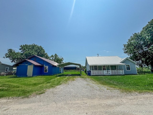 view of front of property featuring a front lawn, a porch, and a carport