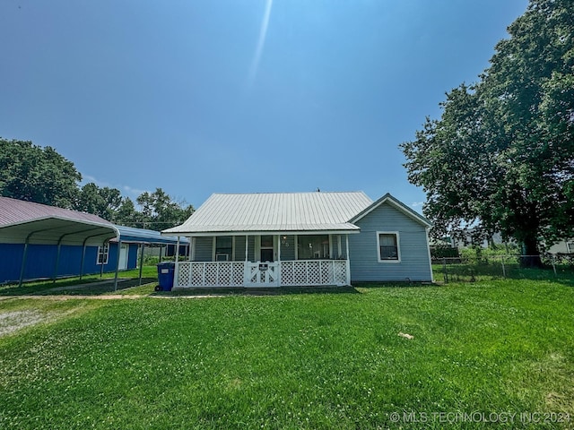 view of front of property featuring covered porch, a front lawn, and a carport