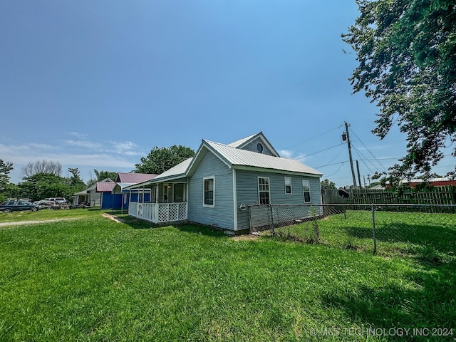 view of side of property featuring a lawn and a porch