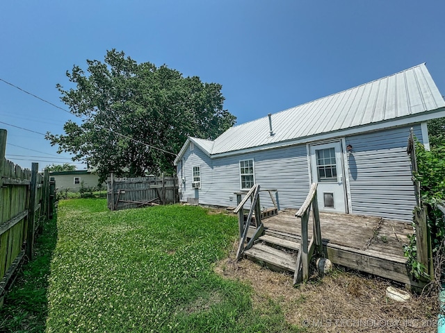 back of property featuring a lawn and a wooden deck