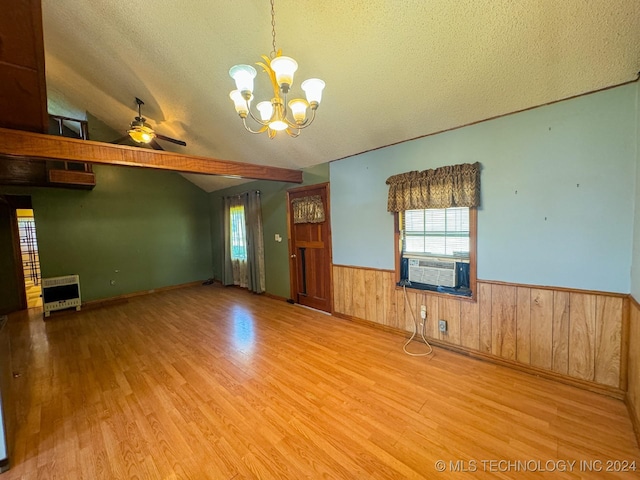 empty room featuring ceiling fan with notable chandelier, a textured ceiling, light wood-type flooring, and lofted ceiling