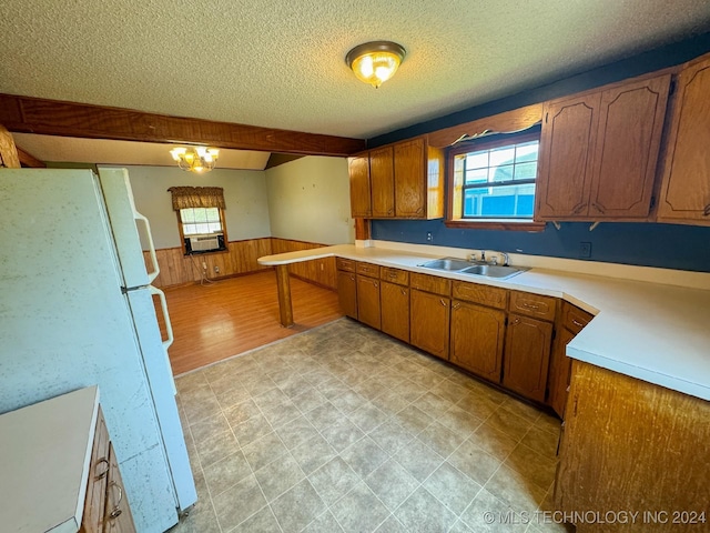 kitchen with sink, white fridge, a chandelier, a textured ceiling, and light hardwood / wood-style floors