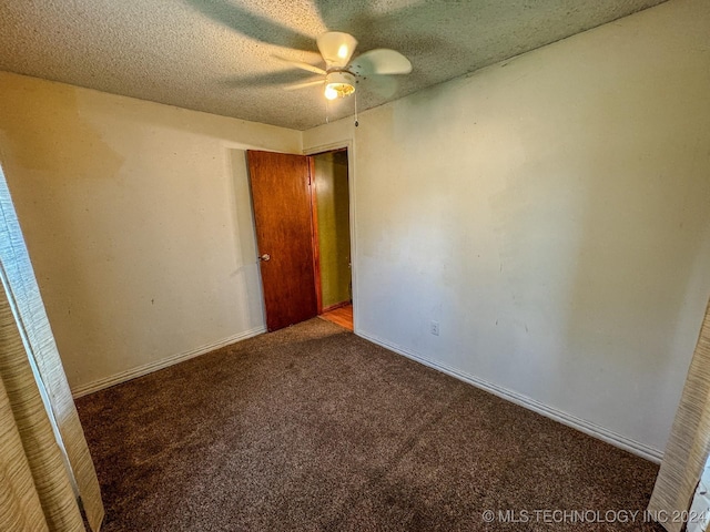 unfurnished room with ceiling fan, carpet floors, and a textured ceiling