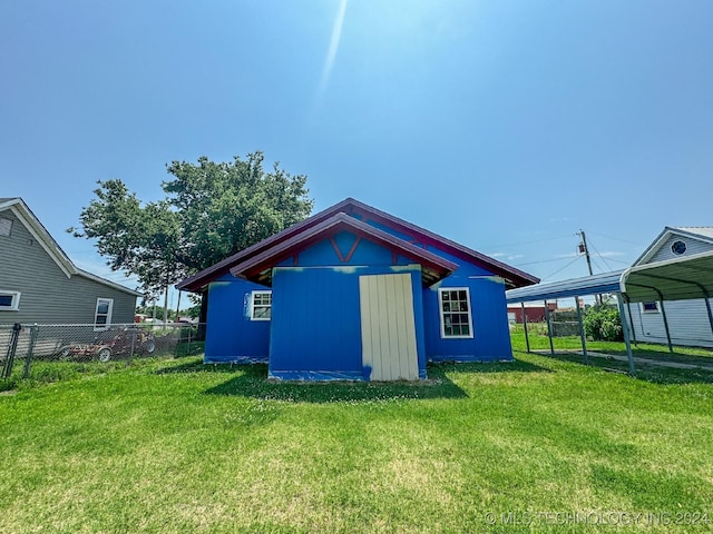 view of outdoor structure featuring a carport and a lawn