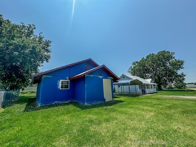 view of side of home with a carport and a yard