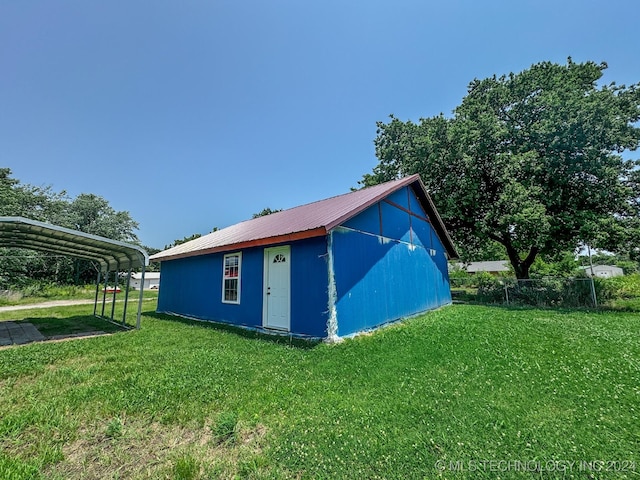 view of home's exterior featuring a yard, an outdoor structure, and a carport