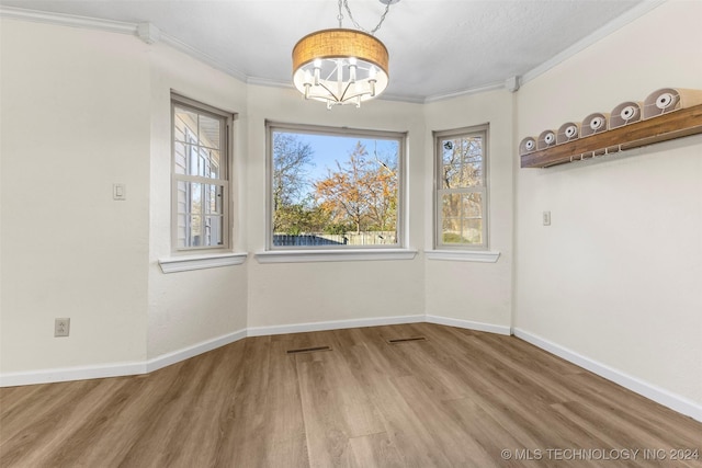 unfurnished dining area with crown molding and hardwood / wood-style floors