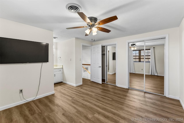 unfurnished bedroom with dark hardwood / wood-style flooring, ensuite bathroom, and ceiling fan