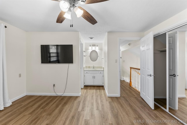 unfurnished bedroom with ceiling fan, ensuite bath, light hardwood / wood-style flooring, and a closet