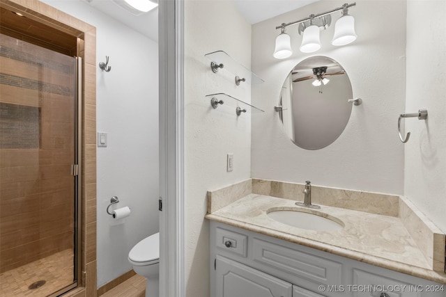 bathroom featuring an enclosed shower, vanity, ceiling fan, wood-type flooring, and toilet