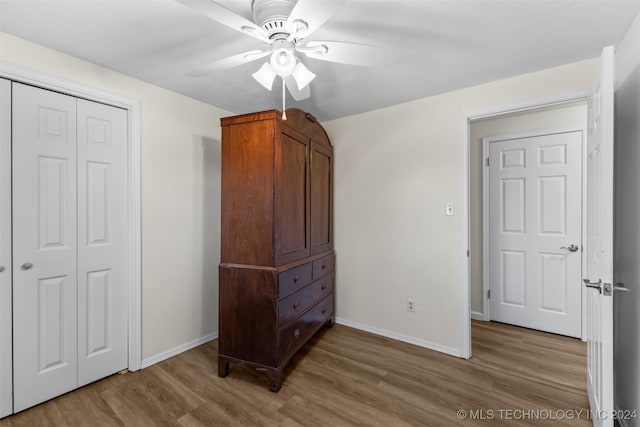 bedroom with ceiling fan, a closet, and wood-type flooring