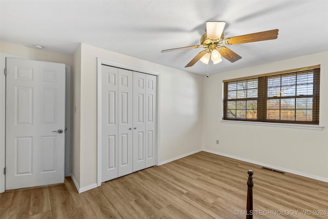 unfurnished bedroom with a closet, light hardwood / wood-style floors, and ceiling fan