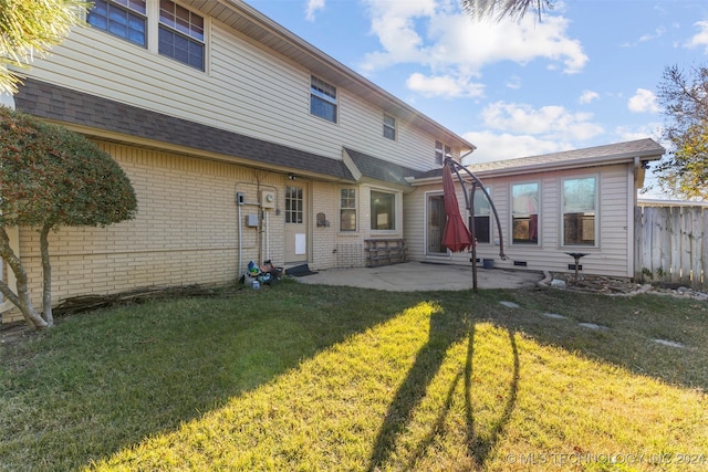 back of house featuring a lawn and a patio