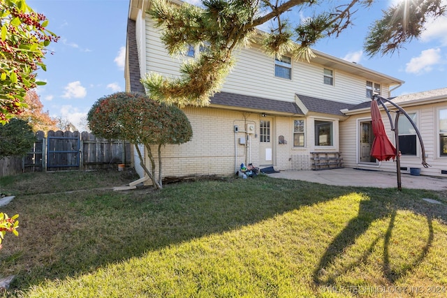 rear view of property featuring a yard and a patio