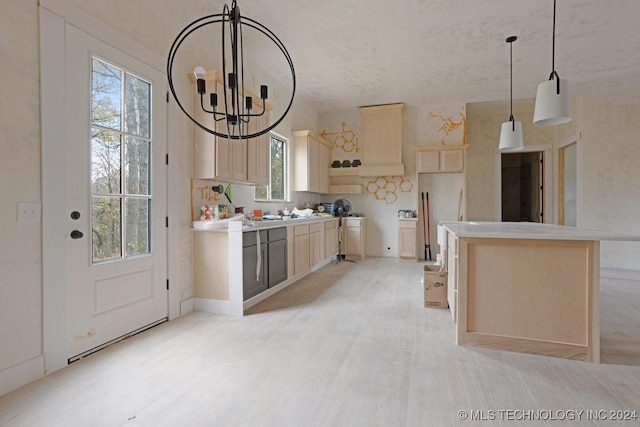 kitchen featuring a chandelier, pendant lighting, light hardwood / wood-style flooring, and a kitchen island