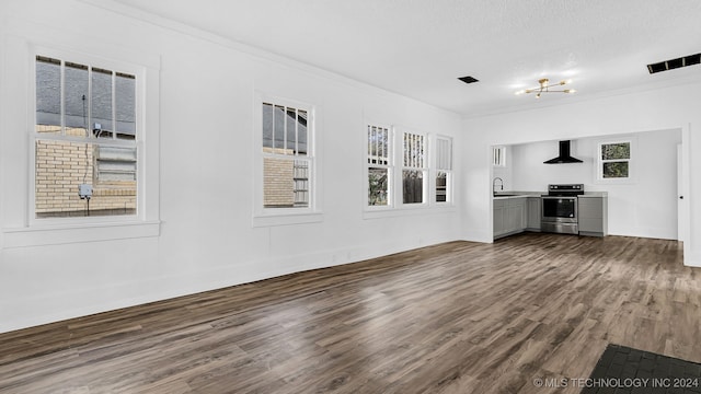 unfurnished living room featuring plenty of natural light, crown molding, wood-type flooring, and a textured ceiling