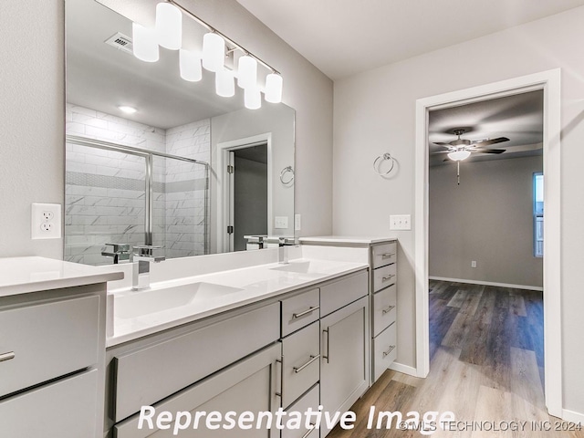 bathroom featuring ceiling fan, vanity, wood-type flooring, and walk in shower