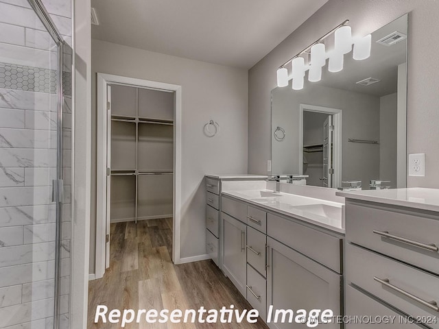 bathroom featuring a shower with shower door, wood-type flooring, and vanity