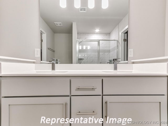 bathroom featuring vanity and an enclosed shower