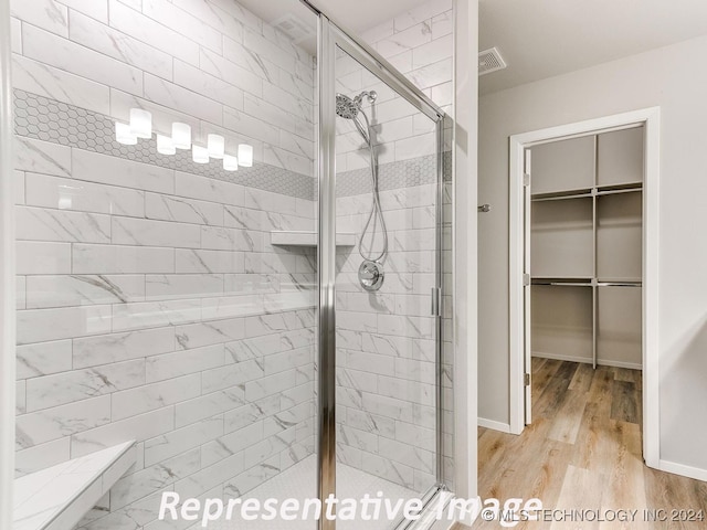 bathroom featuring a shower with door and wood-type flooring